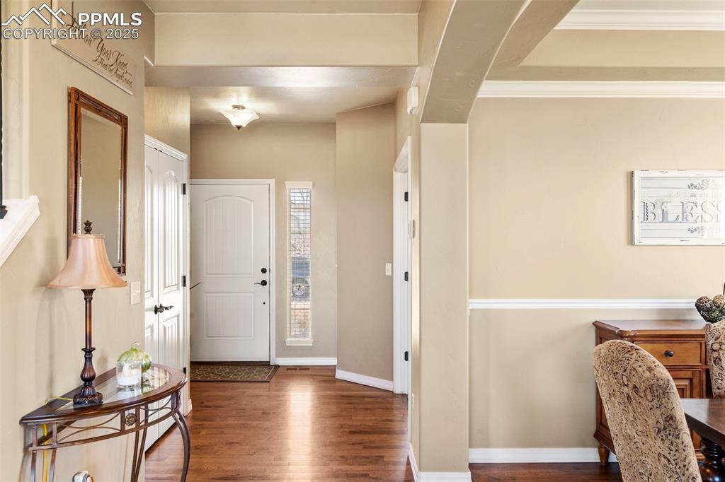 Image 8 of 41: Entrance foyer with wood finished floors and ornamental molding
