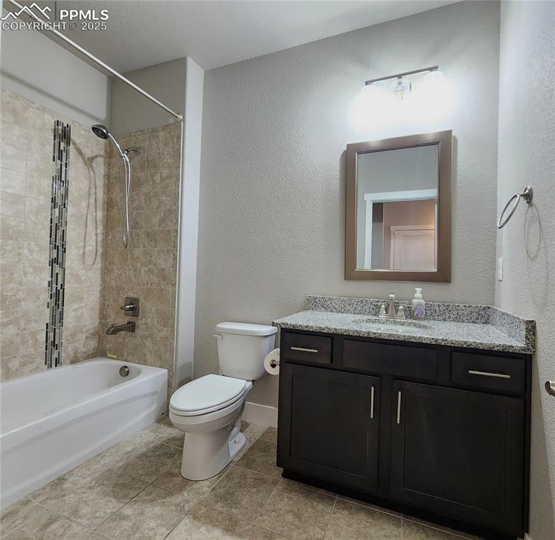 Image 17 of 50: main-level bathroom featuring a granite countertop and designer tile surrou