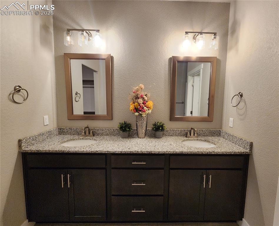 Image 18 of 50: elegant primary bathroom featuring a spacious double vanity with granite co