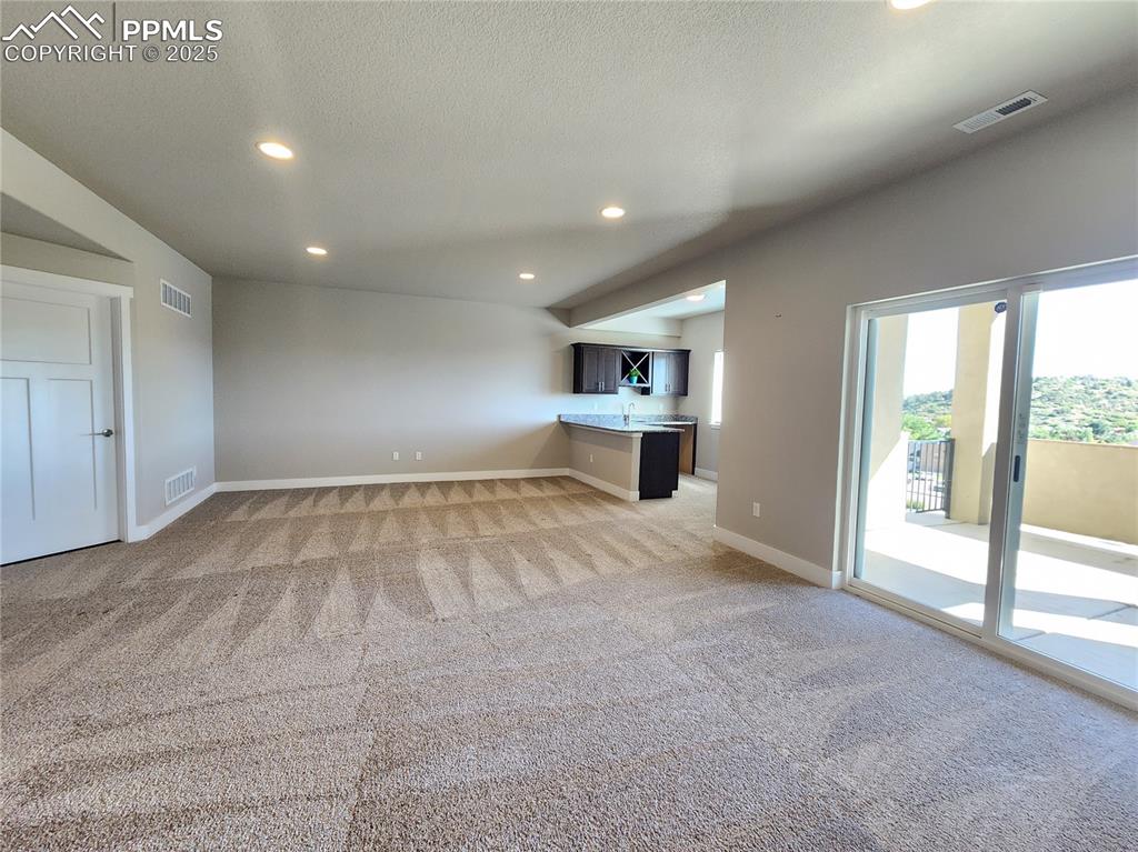 Image 26 of 50: spacious family room showcasing the walk-out sliding door leading to a priv