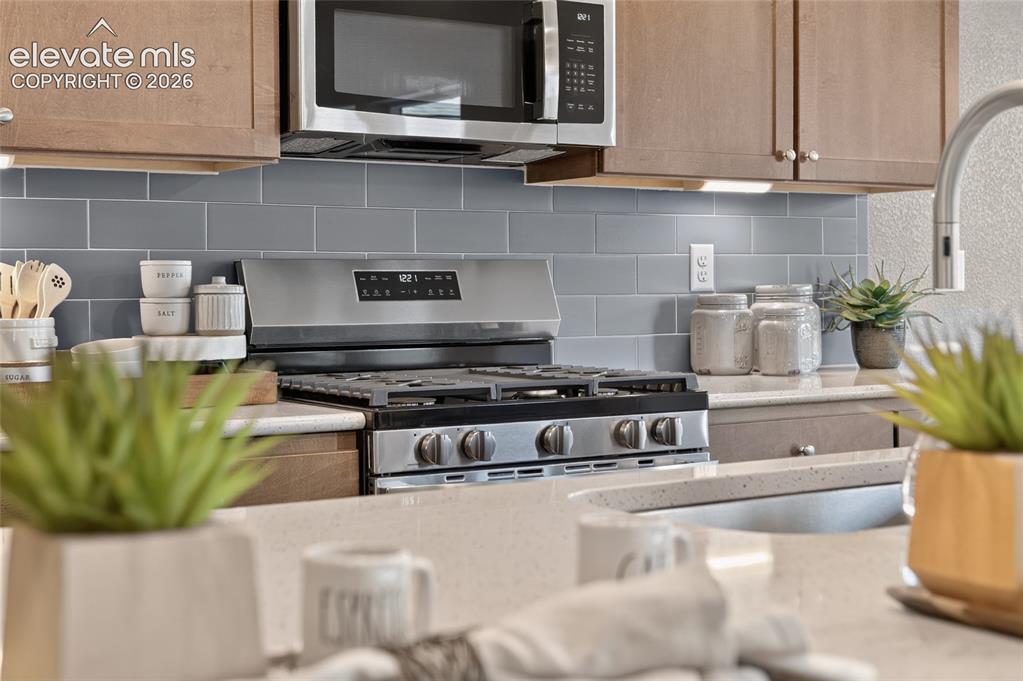 Image 12 of 45: Open-concept kitchen featuring an island with counter seating, stainless st