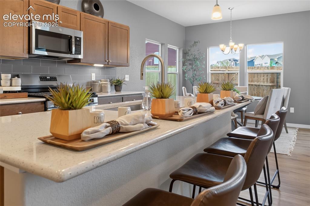 Image 15 of 45: Kitchen featuring wood-finish cabinetry, light-toned countertops, a stainle
