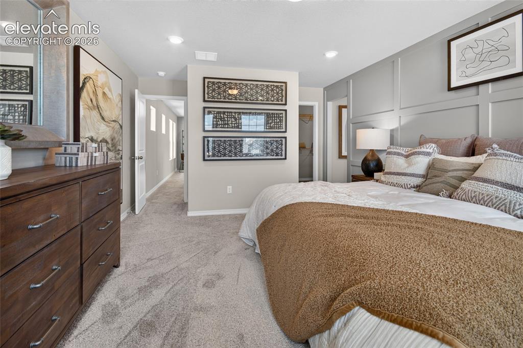 Image 24 of 45: Wall-mounted paneling behind the bed, a window with exterior views, recesse