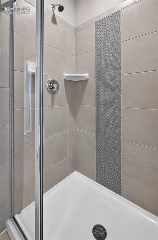 Image 28 of 45: Dual vanity with wood-finish cabinetry, white countertops, and chrome fixtu