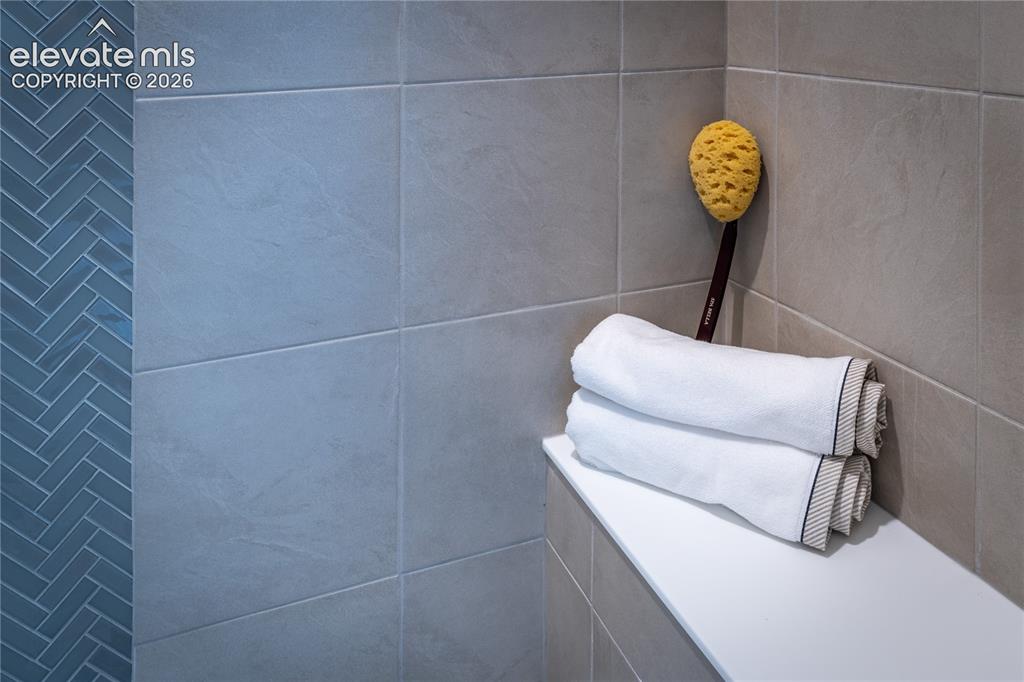 Image 29 of 45: Walk-in shower featuring a glass enclosure, light-toned tile surround, and