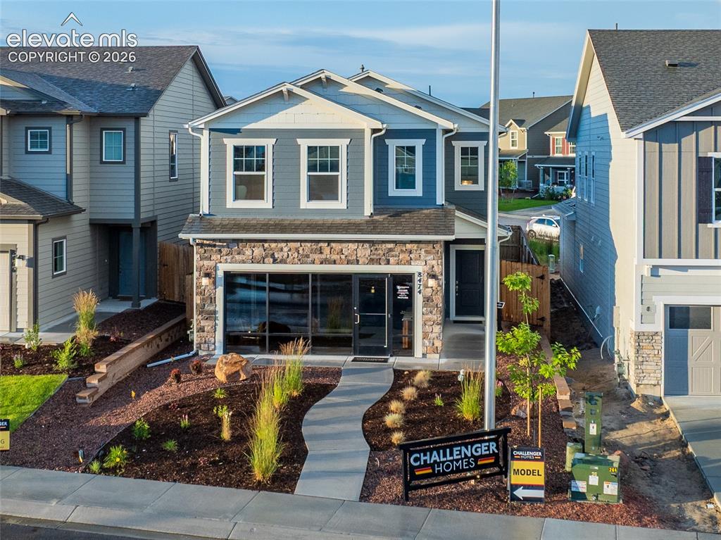 Image 3 of 45: Contemporary facade featuring stone accents, blue siding, and white trim