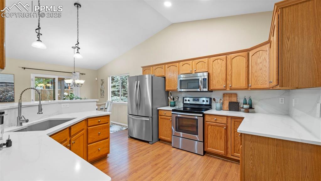 Image 11 of 33: Kitchen with appliances with stainless steel finishes, decorative light fix