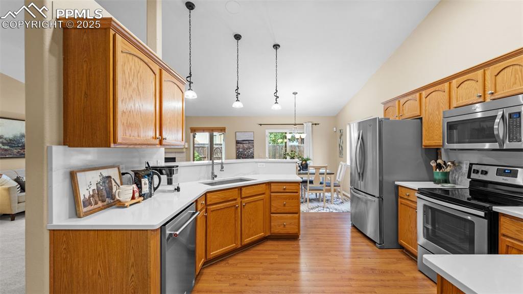 Image 12 of 33: Kitchen featuring stainless steel appliances, decorative light fixtures, li