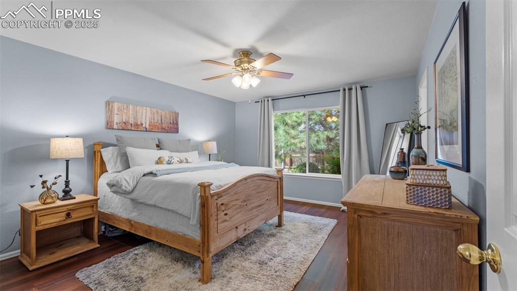 Image 16 of 33: Bedroom featuring dark wood-style floors and ceiling fan