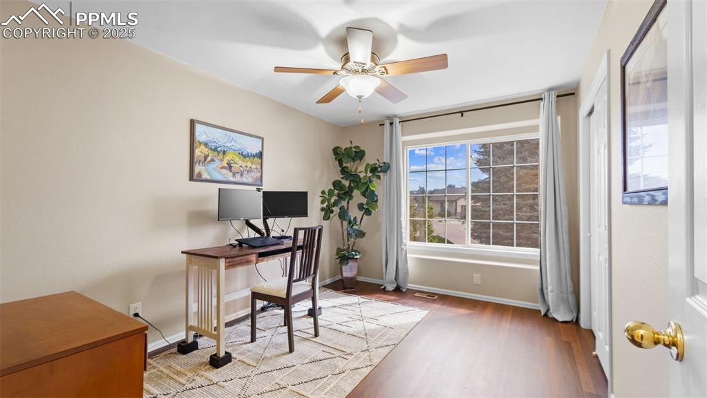 Image 20 of 33: Office area with light wood finished floors and a ceiling fan