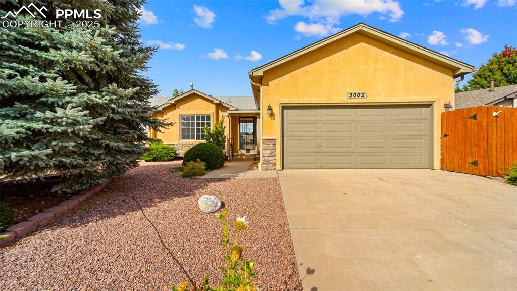 Image 6 of 33: Ranch-style home featuring stucco siding, driveway, an attached garage, and