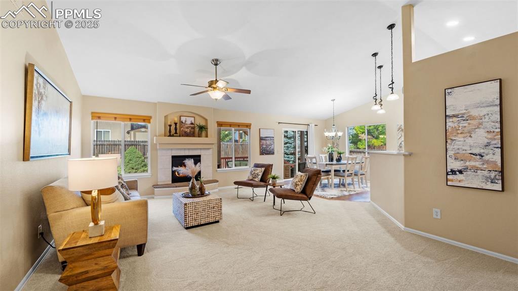 Image 8 of 33: Living area with ceiling fan, plenty of natural light, a tiled fireplace, c