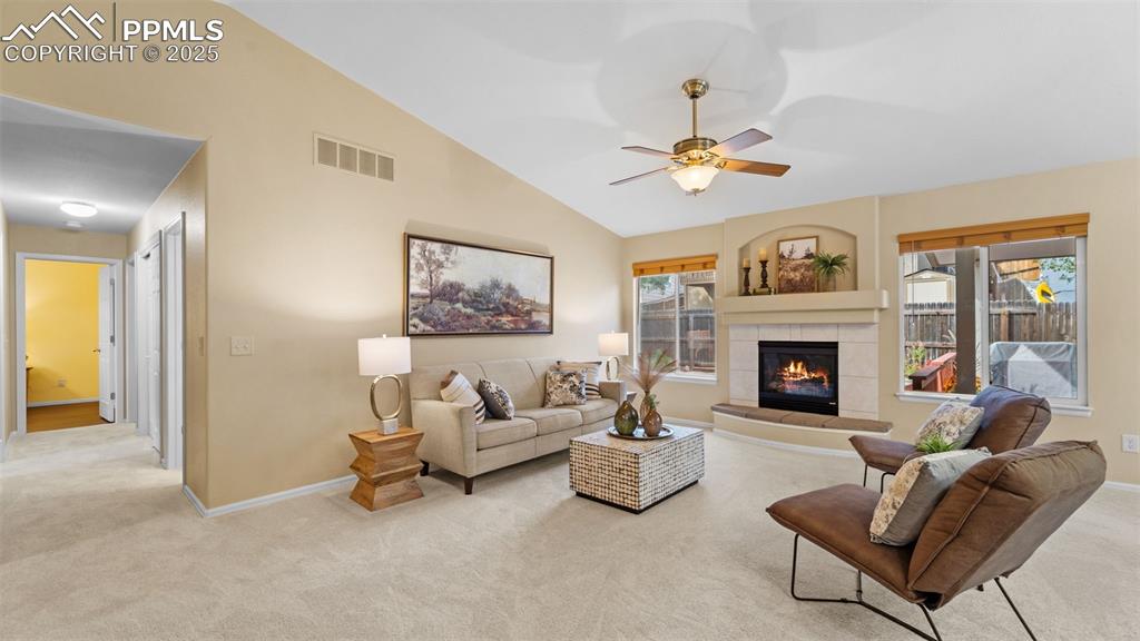 Image 9 of 33: Living area with vaulted ceiling, light colored carpet, ceiling fan, plenty