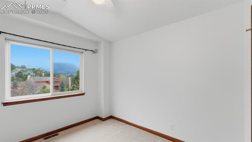 Image 25 of 47: Upper Level Bedroom #1 with neutral carpet and lighted ceiling fan.