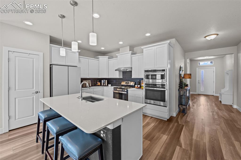 Image 13 of 49: Contemporary kitchen featuring white cabinetry, stainless steel appliances,