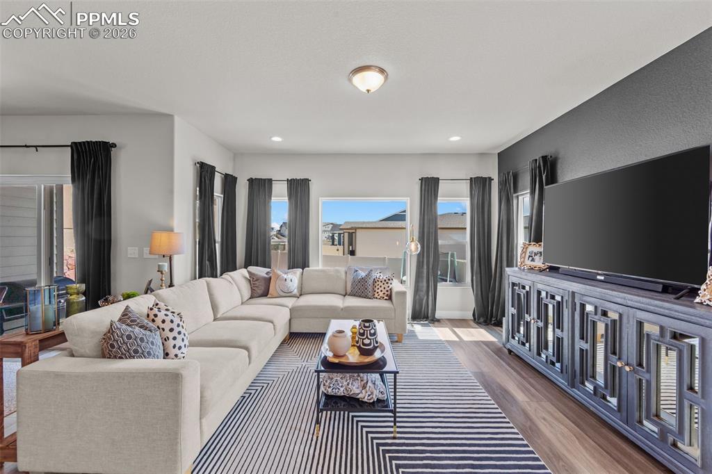 Image 18 of 49: Open-concept living area featuring wood-finish flooring, a contemporary acc