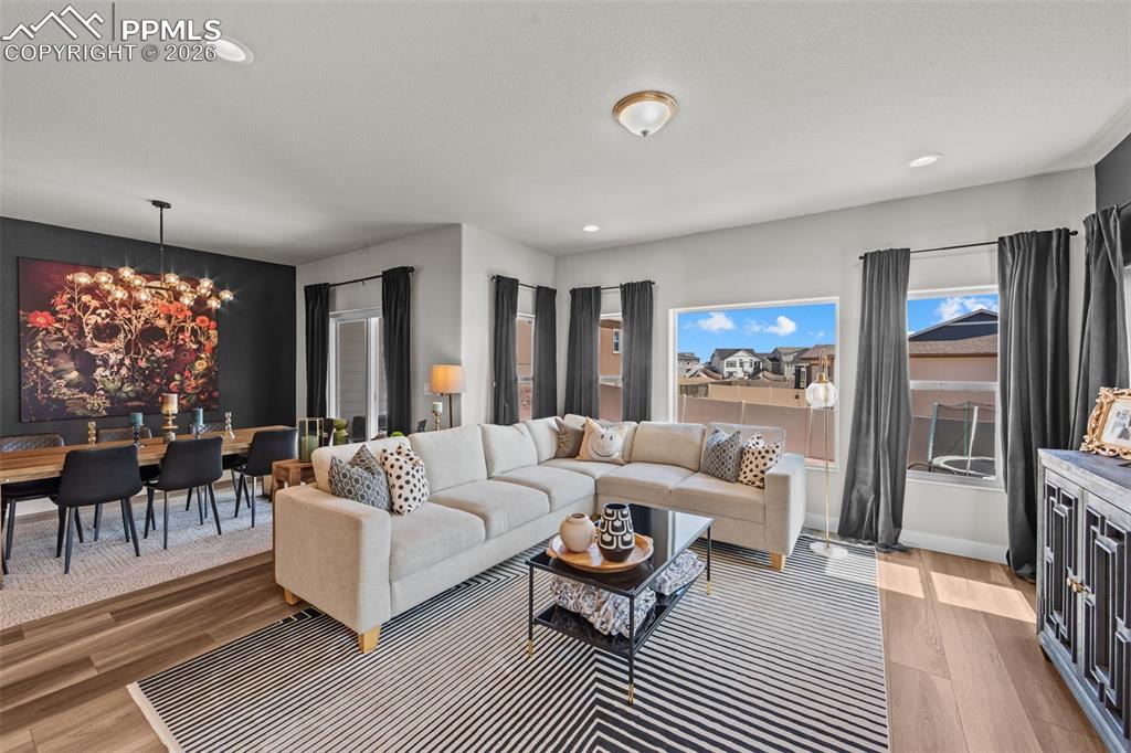 Image 19 of 49: Open concept living area featuring wood-finish flooring, recessed lighting,