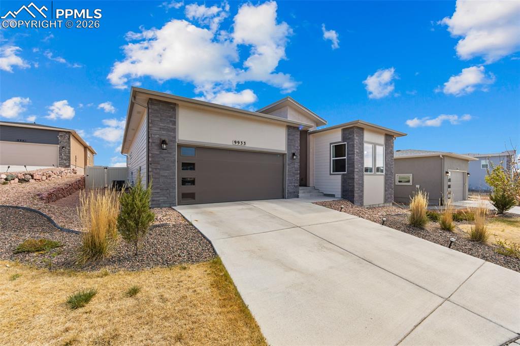 Image 2 of 49: Contemporary exterior featuring stone accents and horizontal siding