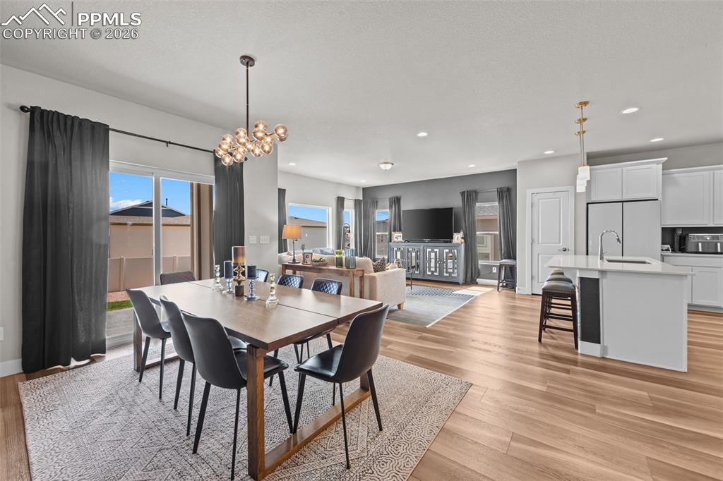 Image 21 of 49: Spacious open-concept living area featuring light wood-finish flooring thro