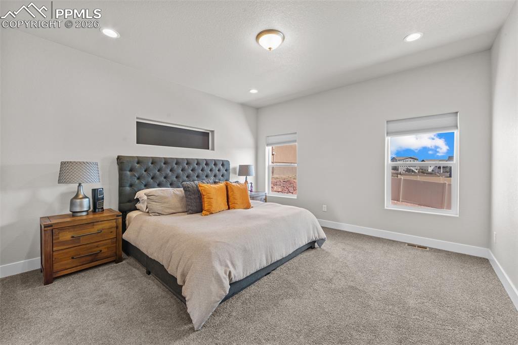 Image 22 of 49: Spacious room featuring light gray walls, plush gray carpeting, recessed li