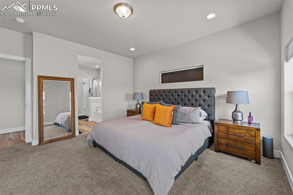 Image 23 of 49: Carpeted bedroom featuring a transom window, recessed lighting, and an open