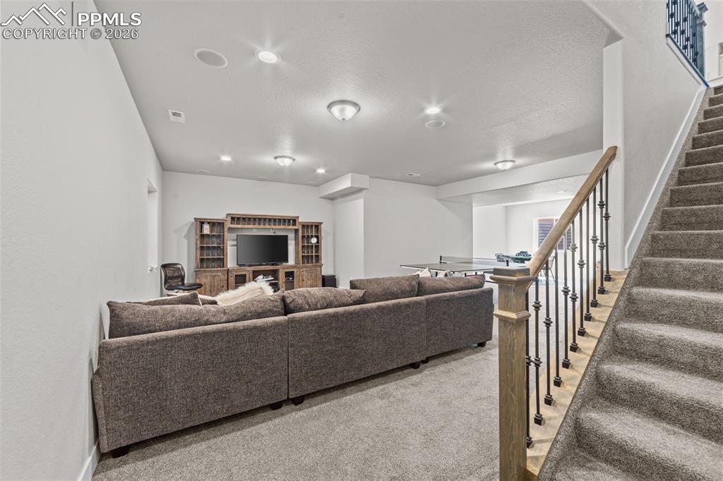 Image 26 of 49: Expansive lower-level recreational space featuring recessed lighting, a bui