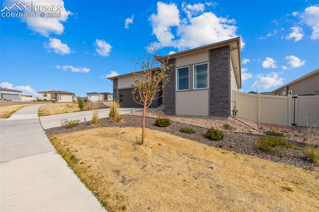 Image 3 of 49: Contemporary exterior featuring stone facade accents and stucco siding