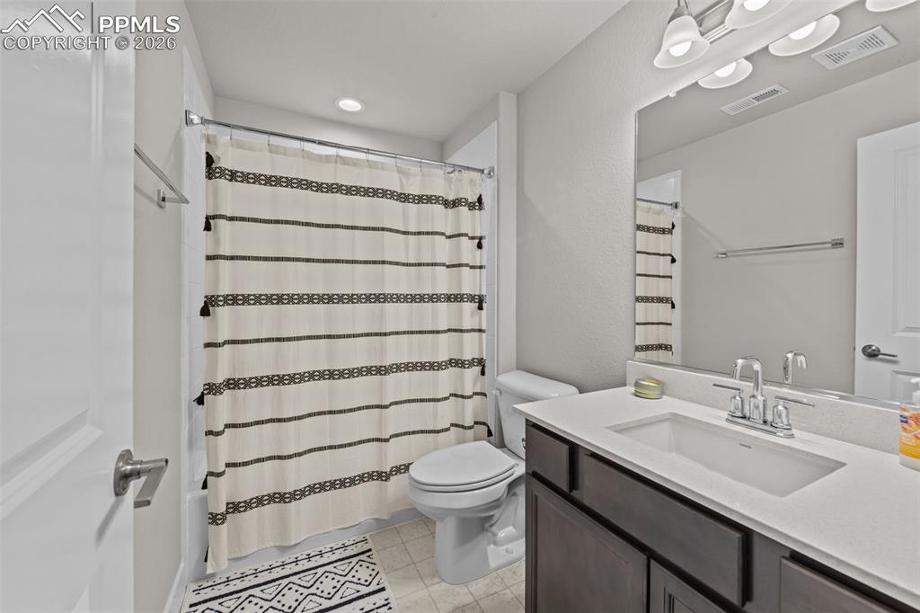 Image 30 of 49: Bathroom featuring a single vanity with a white countertop, dark wood-finis