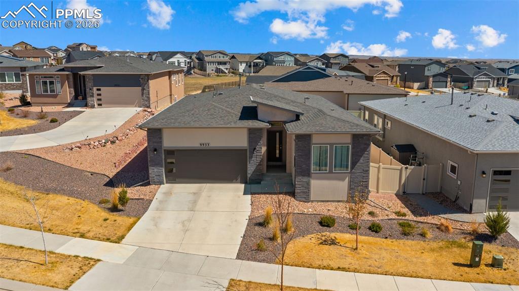 Image 39 of 49: Contemporary single-story residence featuring a gray shingle roof and a two