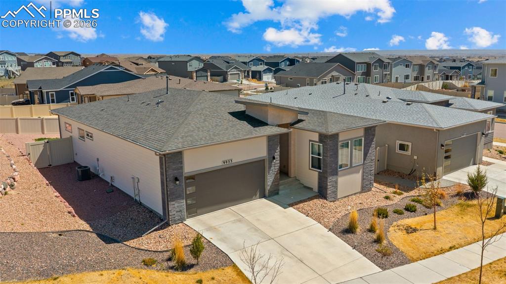 Image 40 of 49: Contemporary single-story residence featuring a two-car garage, stone and s