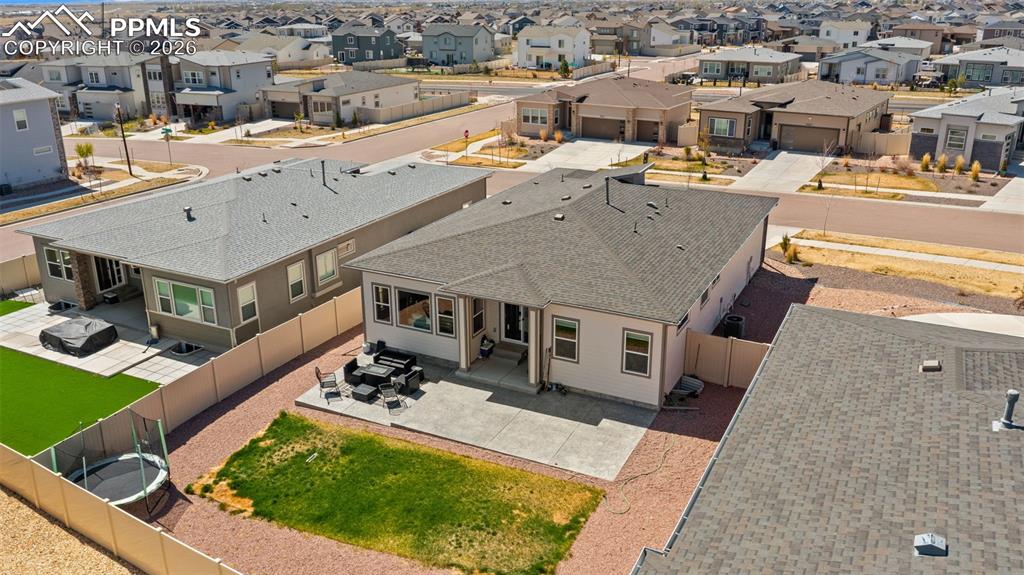 Image 41 of 49: Rear exterior with a concrete patio, landscaped with gravel and a grass are