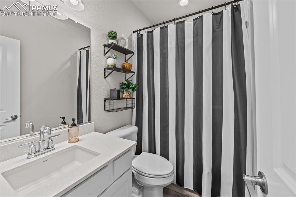 Image 8 of 49: Bathroom featuring a single vanity with an integrated sink, polished chrome