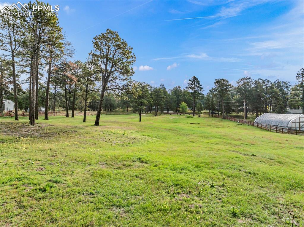 Image 4 of 9: View of grassy yard with an outbuilding, an exterior structure, a rural vie