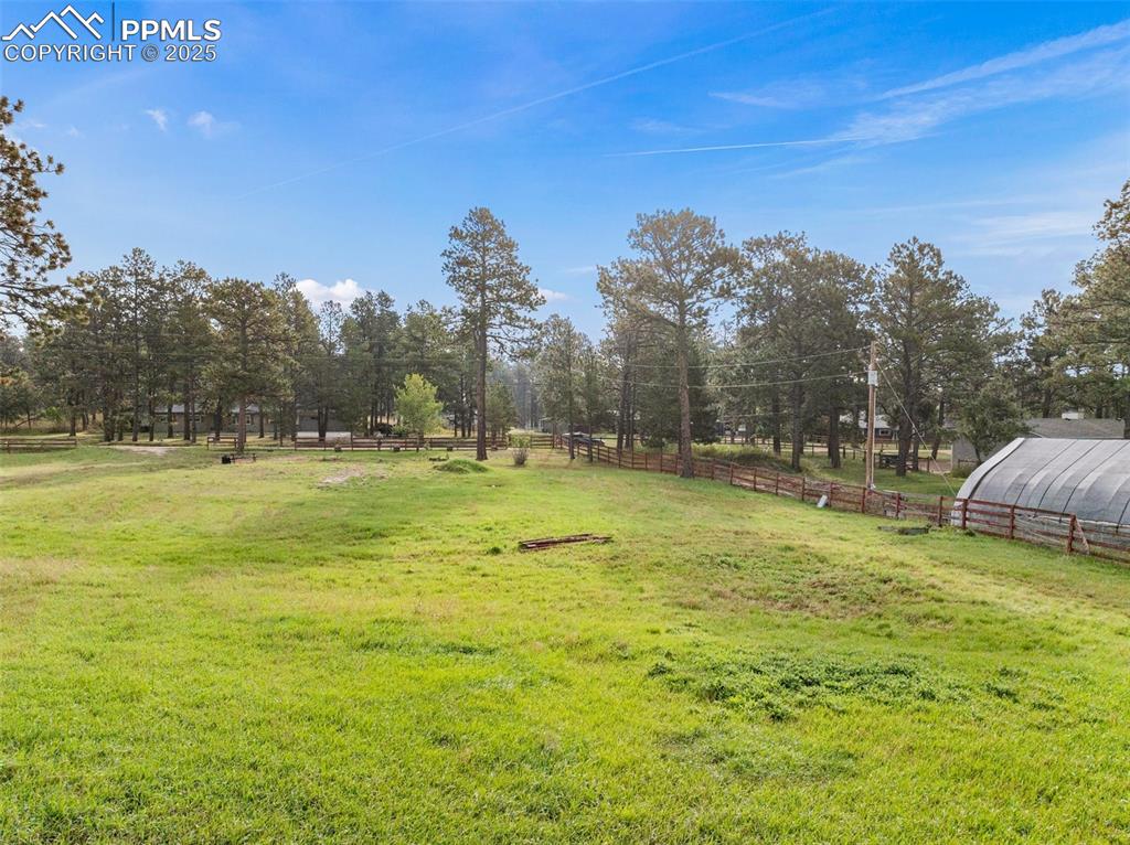 Image 8 of 9: View of yard with a view of countryside, a greenhouse, and an outdoor struc
