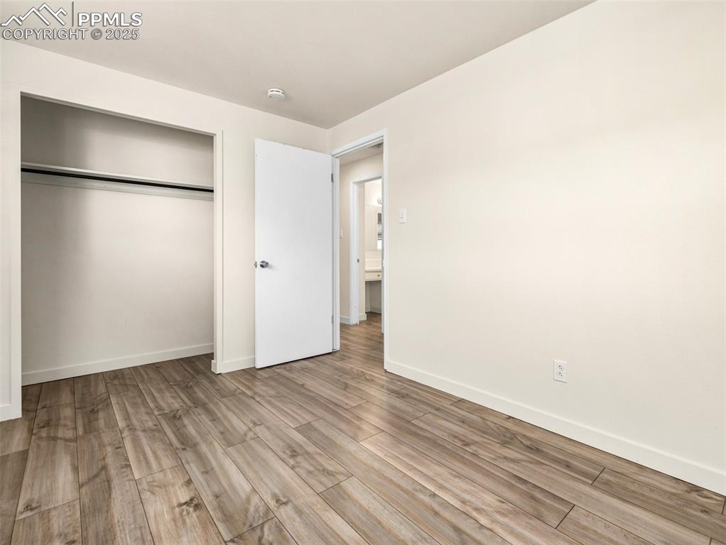 Image 22 of 28: Unfurnished bedroom featuring wood finished floors and a closet