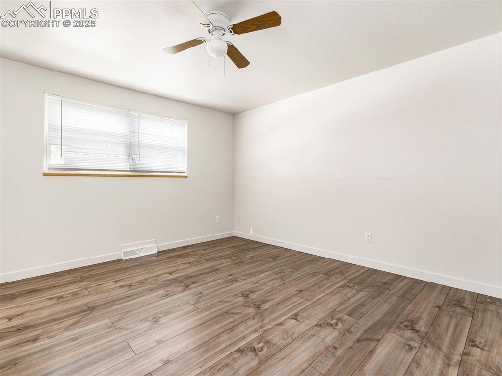 Image 23 of 28: Unfurnished room with wood finished floors and a ceiling fan