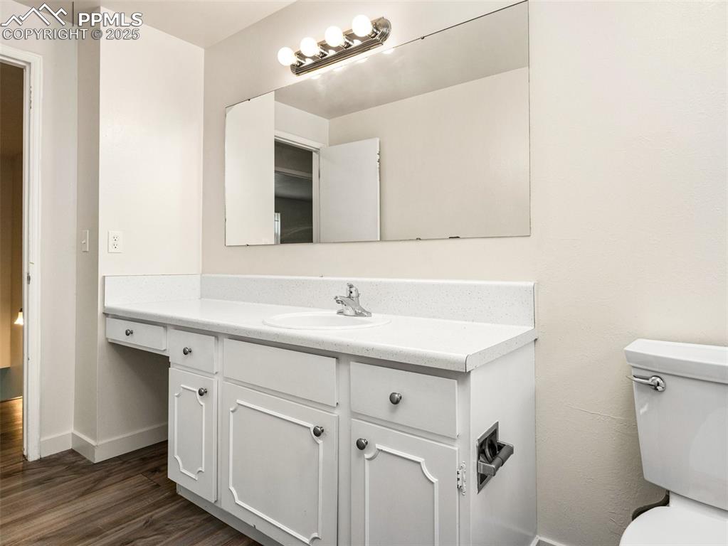 Image 25 of 28: Half bath featuring vanity and dark wood-type flooring