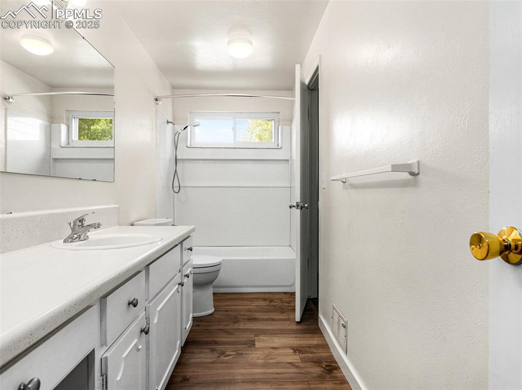 Image 26 of 28: Bathroom featuring vanity, shower combination, dark wood-type flooring, an