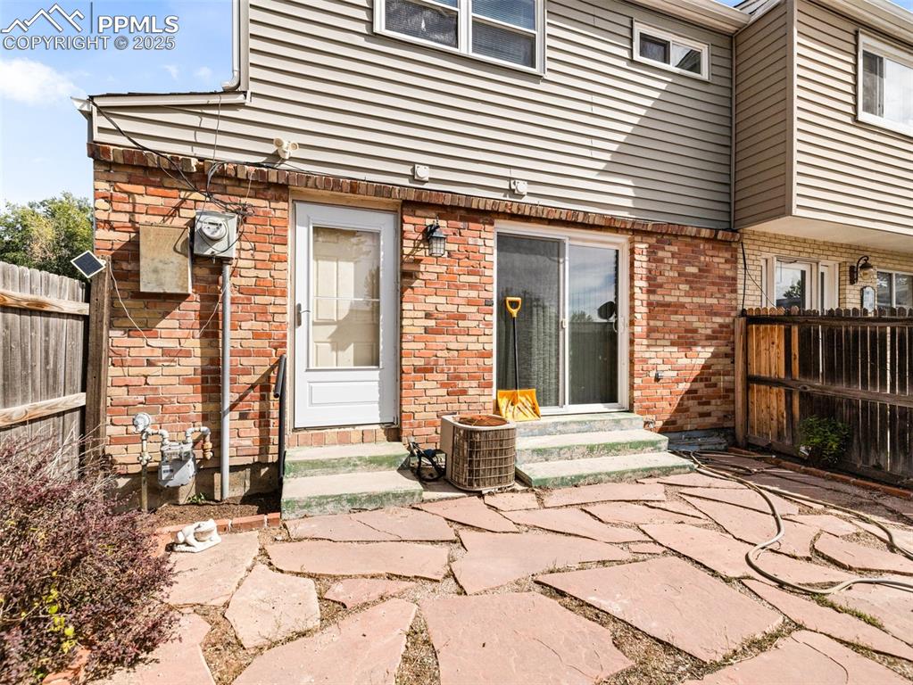 Image 28 of 28: Rear view of property featuring entry steps and brick siding