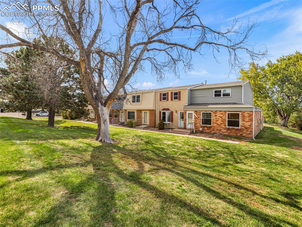 Image 4 of 28: View of front of home with brick siding and a front yard