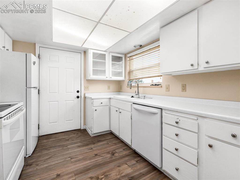 Image 9 of 28: Kitchen featuring white cabinetry, dark wood-style floors, white appliances