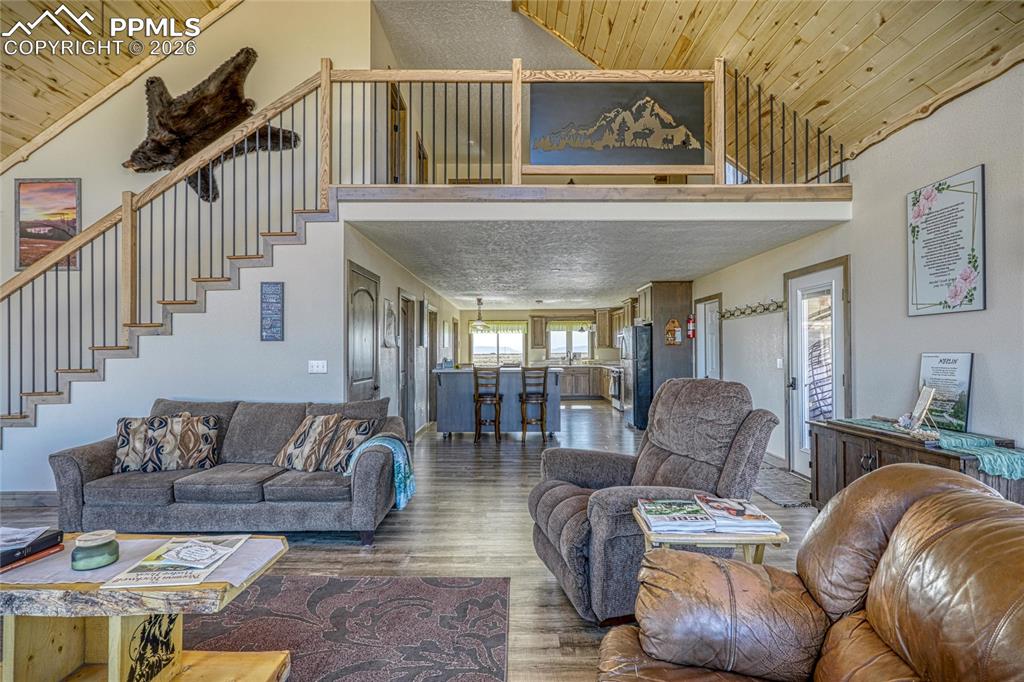 Image 10 of 50: Living area featuring a vaulted wood ceiling and wood finished floors