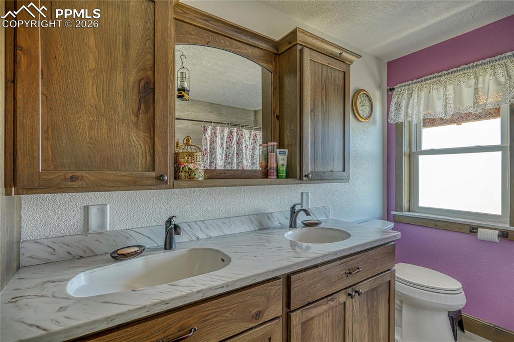 Image 26 of 50: Full bathroom featuring a textured ceiling, a shower with shower curtain, a