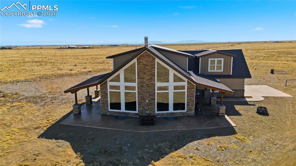 Image 3 of 50: Rear view of house with stone siding, a view of rural / pastoral area, and