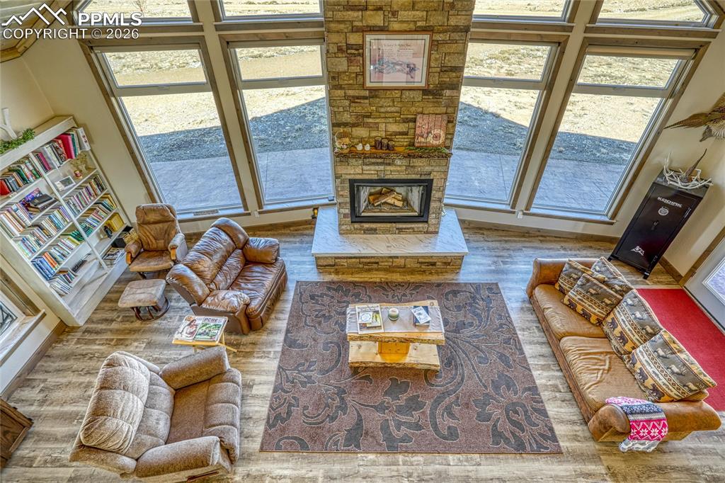 Image 30 of 50: Living room with wood finished floors and a stone fireplace