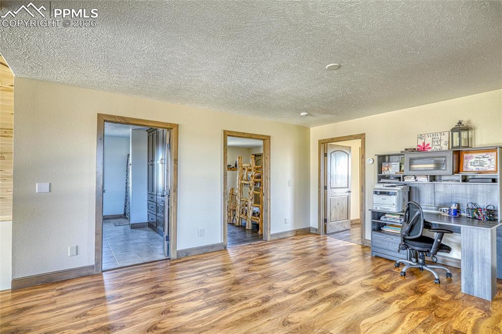 Image 35 of 50: Office area featuring light wood-type flooring and a textured ceiling