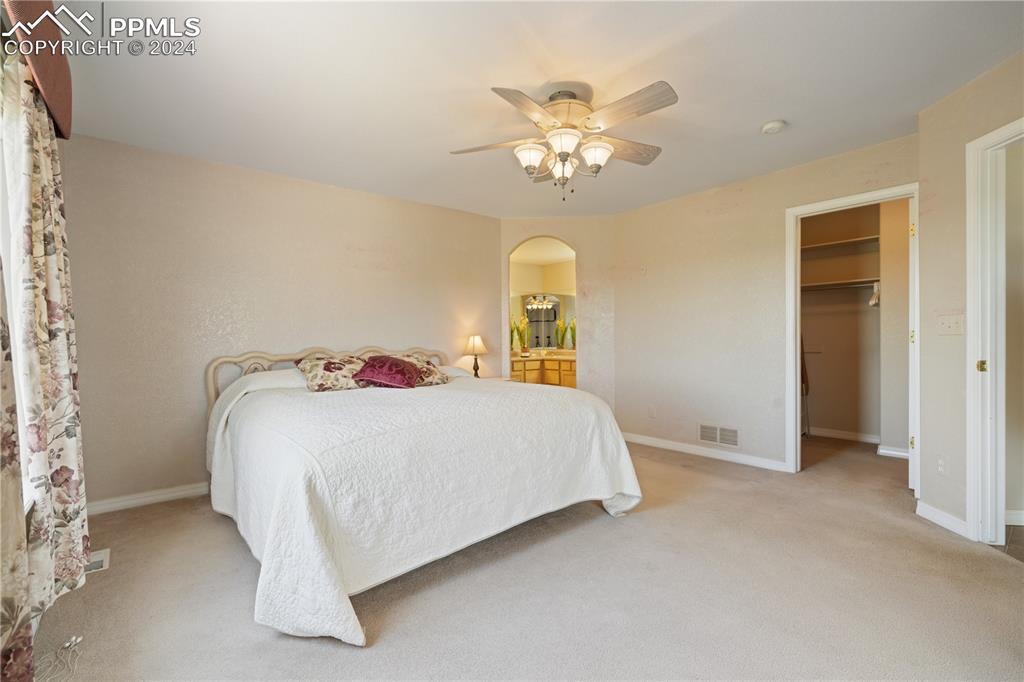 Image 22 of 49: Carpeted bedroom with a spacious closet, ceiling fan, and a closet