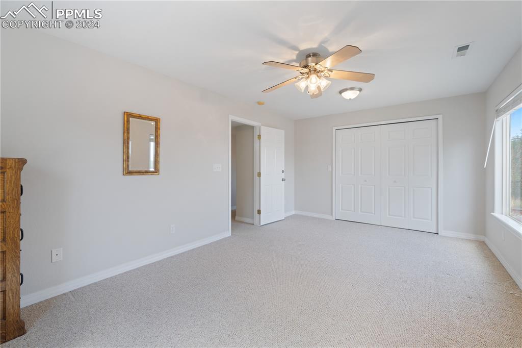 Image 30 of 49: Unfurnished bedroom featuring a closet, ceiling fan, and light carpet