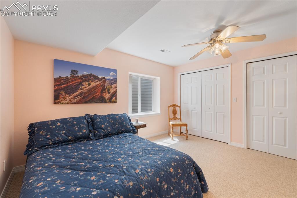 Image 33 of 49: Carpeted bedroom featuring multiple closets and ceiling fan