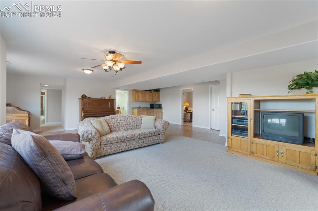 Image 39 of 49: Carpeted living room with ceiling fan